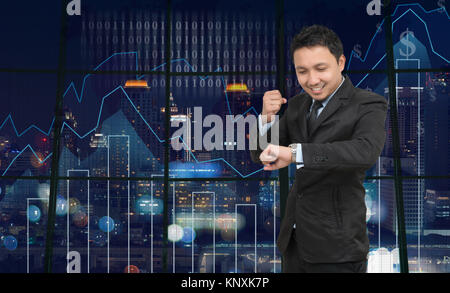 Asian Businessman looking at watch on theTrading graph over the cityscape at night and world map background,Business financial concept Stock Photo