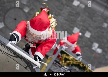 Lucerne, Switzerland - 3 Dec 2017: As Christmas decorations, a rope team of Santa Claus puppets is climbing up the facade of a house at Lucerne, Switz Stock Photo