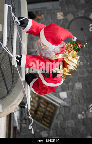 Lucerne, Switzerland - 3 Dec 2017: As Christmas decorations, a Santa Claus puppet with Christmas presents is climbing up the facade of a house at Luce Stock Photo