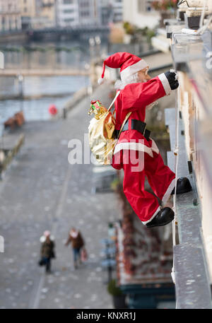 Lucerne, Switzerland - 3 Dec 2017: As Christmas decorations, a Santa Claus puppet with Christmas presents is climbing up the facade of a house at Luce Stock Photo