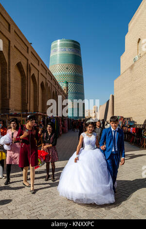 A Young Uzbek Couple Walk Through The Streets Of Khiva After Getting Married, Khiva, Uzbekistan Stock Photo