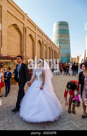 A Young Uzbek Couple Walk Through The Streets Of Khiva After Getting Married, Khiva, Uzbekistan Stock Photo