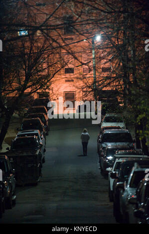 A woman walks alone towards Dorchester Heights in South Boston Stock Photo