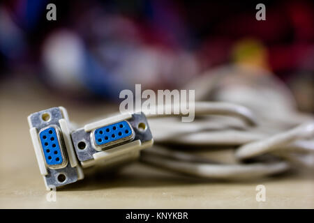 old computer wires. Cables lpt, com1 and com2 for desktop and laptop computers. Wooden table, black background. Stock Photo