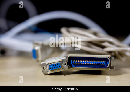 old computer wires. Cables lpt, com1 and com2 for desktop and laptop computers. Wooden table, black background. Stock Photo