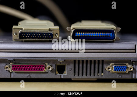 old computer wires. Cables lpt, com1 and com2 for desktop and laptop computers. Wooden table, black background. Stock Photo