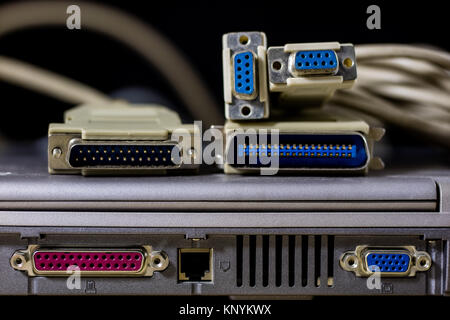 old computer wires. Cables lpt, com1 and com2 for desktop and laptop computers. Wooden table, black background. Stock Photo