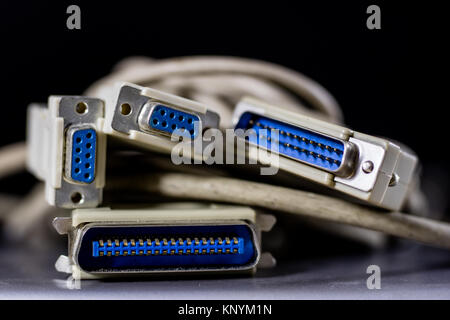 old computer wires. Cables lpt, com1 and com2 for desktop and laptop computers. Wooden table, black background. Stock Photo