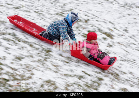 Brother and sister (5 and 3 yrs old) sledging together in Quebec City