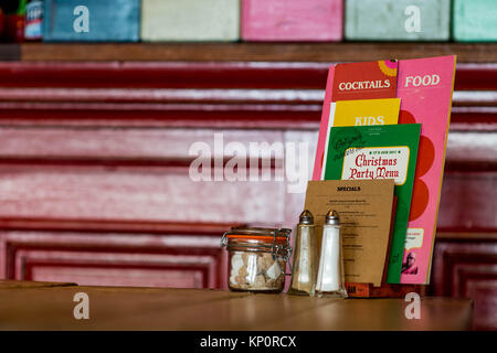 Wooden Table Place Setting in a Trendy Cosy Restaurant With Salt Pepper and Menues Stock Photo