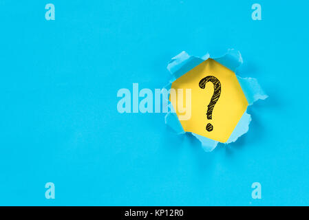 blue torn paper revealing question mark symbol on yellow paper. question mark background Stock Photo