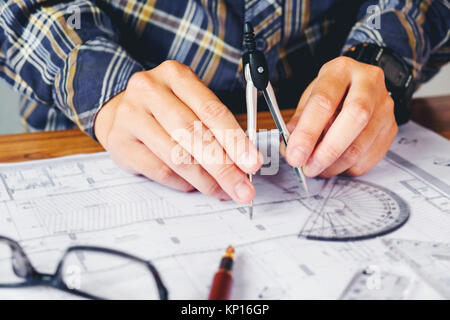 Architect or engineer working in office on blueprint. Architects workplace , blueprints, ruler, helmet and divider. Construction concept. Engineering  Stock Photo
