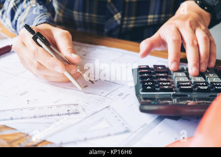 Architect or engineer working in office on blueprint. Architects workplace , blueprints, ruler, helmet and divider. Construction concept. Engineering  Stock Photo