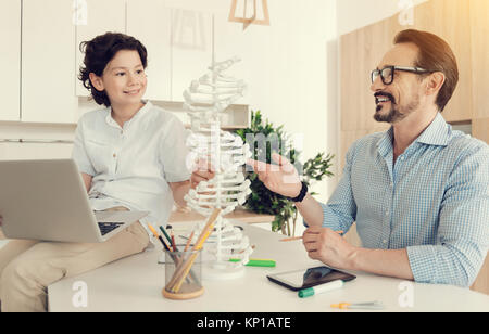 Happy positive man pointing at the DNA model Stock Photo