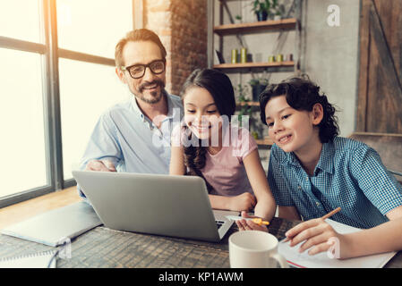 Delighted smart children working on the laptop Stock Photo