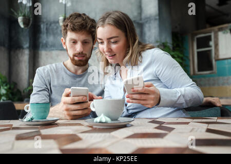 Couple with smartphones in cafe Stock Photo