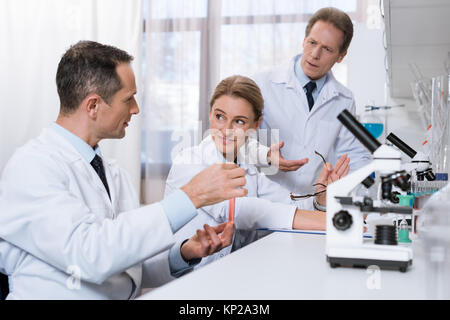 Scientists examining test tube Stock Photo