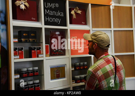 A tourist buying Manuka honey in Auckland, New Zealand. Stock Photo