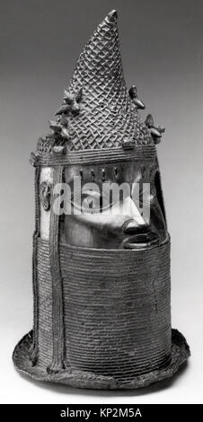 This brass head sculpture from the Edo peoples, dated to the 18th–19th century, represents an iyoba (queen mother) of the Benin Kingdom. It features a high and narrow collar, extensive hair ornament, and a pierced crown. The forward-pointing peaks of the coral-beaded crown distinguish it from heads of obas. The sculpture is cast in brass and iron. Stock Photo
