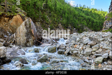 Mountain river in gorge. Streams of water fall from fragments of rock. East Sayan. Russia Stock Photo