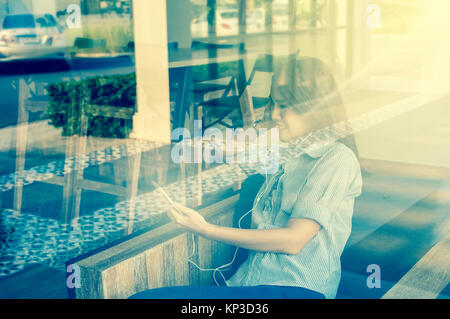 Businesswomen with casual suit using the smart phone in the coffee shop,shooting from out of windows, business technology concept Stock Photo