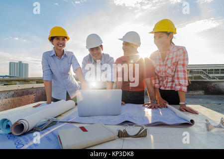 Happy professional construction engineers working with Corporate Colleagues Teamwork and equipment such as blueprint, Safety glasses and technology la Stock Photo