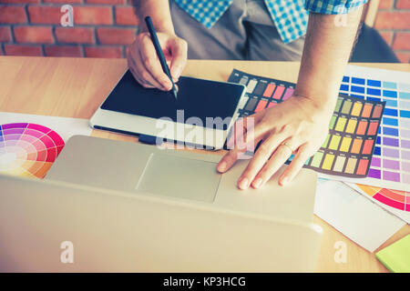 Graphic designer drawing on graphics tablet at workplace Stock Photo