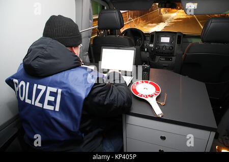 Schoenberg, Germany. 13th Dec, 2017. A police officer checks the ID with a mobile data device at the former border crossing point Germany/Czech Republic near Schoenberg, Germany, 13 December 2017. Especially combating of crime involving narcotic drugs is one of the focus points in the collaboration between the regional police directory Karlovy Vary (Czech Republic) in the course of a joint EU project. Credit: Bodo Schackow/dpa-Zentralbild/dpa/Alamy Live News Stock Photo