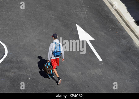 Man Walking Down Street Following Directional Arrow Aigues-Mortes, Gard, France Stock Photo