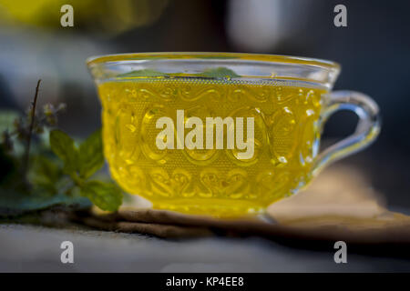 Tea of holy basil,tulsi,Ocimum tenuiflorum,in a transparent cup with leaves beneficial for heart diseases and stress. Stock Photo