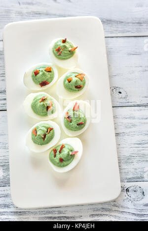 Spinach and bacon deviled eggs Stock Photo