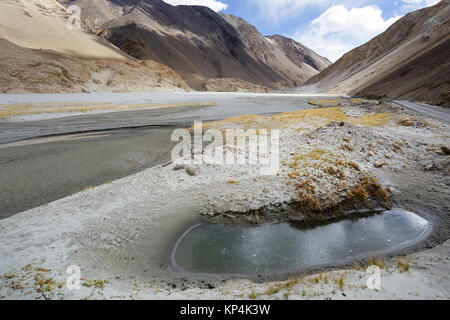 Mountain road leading from Chang La pass to Pangong Tso with water holes and herds of yaks grazing in the back, Ladakh, Jammu and Kashmir, India. Stock Photo