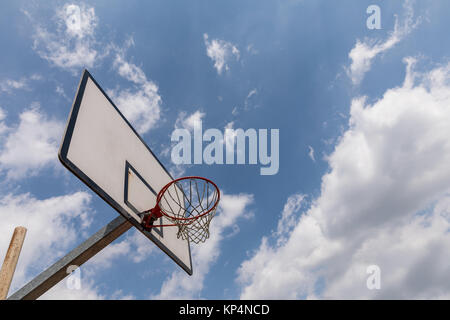 basketball backboard on blue cloudy sky background, Outdoor basketball hoop on a cloudy day Stock Photo