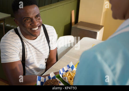 Waitress serving breakfast to customer in restaurant Stock Photo