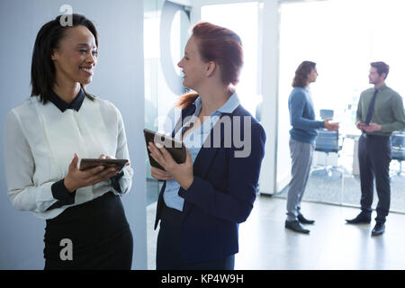 Female executives discussing over digital tablet in office Stock Photo