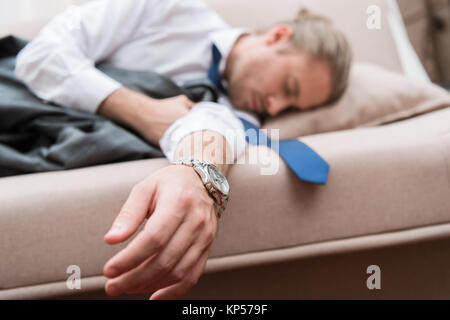 Tired businessman sleeping on a sofa Stock Photo