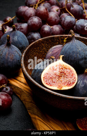 Ripe Grapes and Figs on dark concrete background Stock Photo