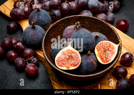 Ripe Grapes and Figs on dark concrete background Stock Photo