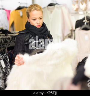 Beautiful woman shopping in clothing store. Stock Photo