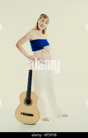 Schwangere Frau mit Gitarre - pregnant woman with guitar Stock Photo
