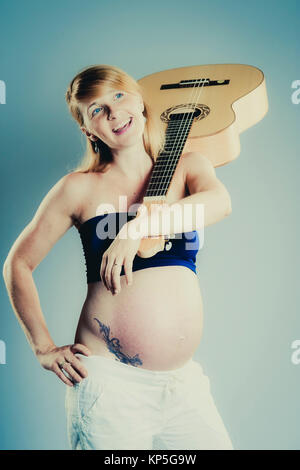 Schwangere Frau mit Gitarre - pregnant woman with guitar Stock Photo