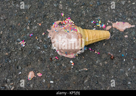 melted ice cream cone on pavement Stock Photo