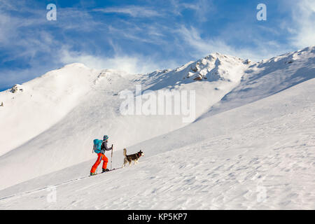 Young man backcountry skiing, going uphill on the mountain, with Stock Photo