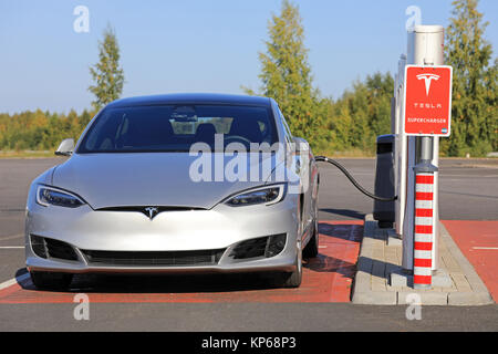 TOIJALA, FINLAND - SEPTEMBER 24, 2017: Silver Tesla Model S fully electric car charges battery at Tesla Supercharger charging station in Toijala, Finl Stock Photo