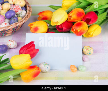 Colorful tulips and Easter candy around a blank envelope Stock Photo