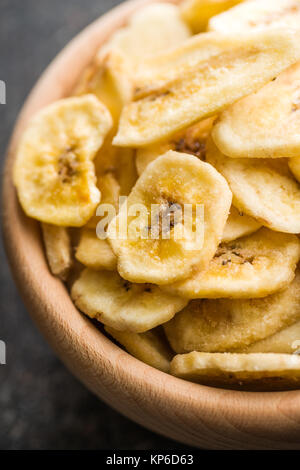Dried banana chips in wooden bowl. Stock Photo