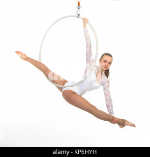 A young woman performs the acrobatic elements in the air ring. Studio ...