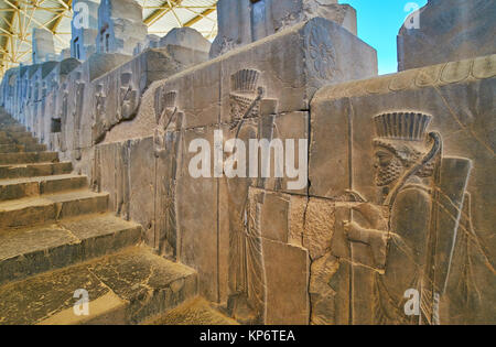 The walk along the ancient East Stairs of Apadana with a view on preserved reliefs, depicting Persian soldiers, Persepolis, Iran. Stock Photo