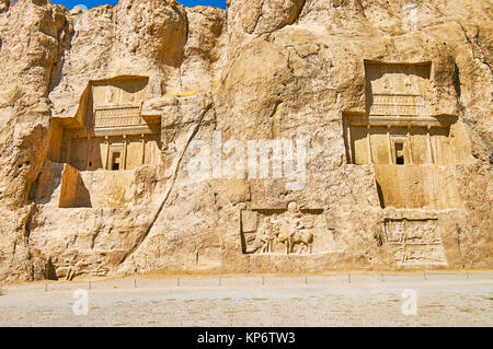 The giant tombs of Naqsh-e Rustam archaeological site are neighboring with equestrian reliefs, carved in rocky cliff, Iran. Stock Photo