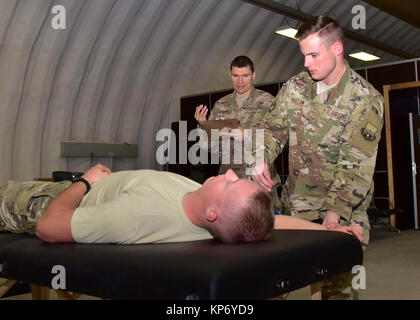 Staff Sgt. David Dillow, 386th Expeditionary Medical Group physical therapy technician, measures the right shoulder range of motion of Senior Airman Calvin Lourens, 386th Expeditionary Logistics Readiness Squadron passenger service specialist, Dec. 7, 2017, while Capt. Eric Walter, 386th EMDG physical therapy element chief, observes at an undisclosed location in Southwest Asia. (U.S. Air Force Stock Photo